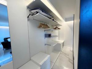 a white closet with white shelves and wooden hangers at Hotel Alpha in Sant'Agnello