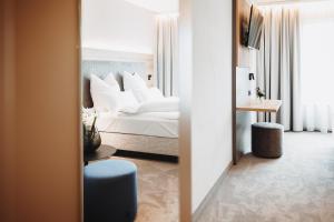 a bedroom with a white bed and a mirror at Hotel VIVO in Schierling