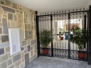 a black iron gate with potted plants on it at KLAPKA PROVANCE APARTMAN in Kaposvár