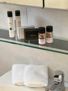a bathroom shelf with towels and products on it at Iakovakis Seaside Exclusive Apartments in Koropi