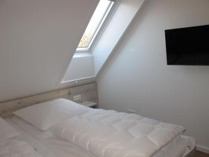 1 dormitorio con cama blanca y ventana en Holiday Home Cuxland Ferienpark-5 by Interhome, en Wremen