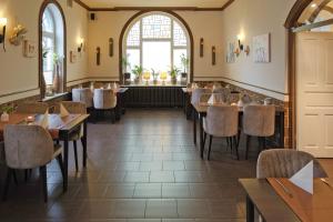 a restaurant with tables and chairs and a window at Hotel-Restaurant Holsteiner Hof in Geesthacht