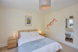 a bedroom with a bed and a dresser and a window at Old Orchard in Otterford