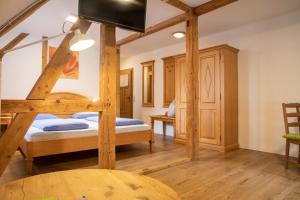 a bedroom with two bunk beds and a tv at Naturhotel Holzwurm in Sasbachwalden