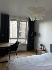 1 dormitorio con cama, escritorio y ventana en Blue Apartment, en Kielce