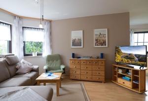a living room with a couch and a flat screen tv at Ferienwohnung Familie Weber in Losheim