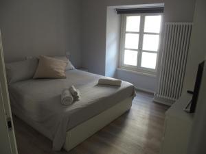 Un dormitorio con una cama con toallas y una ventana. en [M.S.A. Il Salotto Casalese], en Casale Monferrato