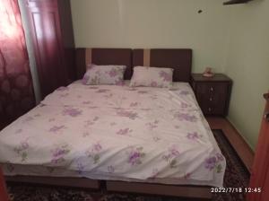 Un dormitorio con una cama con flores rosas. en Apartment Lameram, en Sarajevo
