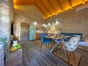 a kitchen with a table and blue chairs in a room at Kostela Stone House in Stolac