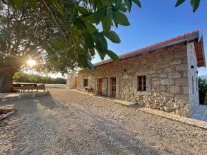 a stone building with a bench in front of it at Kostela Stone House in Stolac