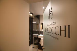 Habitación con baño con espejo y lavabo. en Palazzo Bellocchi - Suites & Apartments, en Brindisi