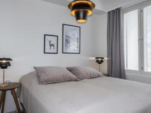 a white bedroom with a bed and two lamps at Holiday Home Alakuuntie 2- as-17 by Interhome in Sirkka