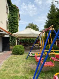 un parque infantil en un patio con una tienda de campaña en Dom Gościnny Batawia en Łazy