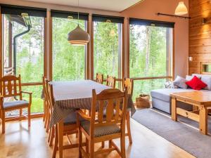 uma sala de jantar com uma mesa, uma cama e janelas em Holiday Home Kanervarinne by Interhome em Vuokatti