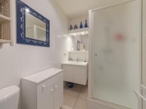 een witte badkamer met een wastafel en een spiegel bij Studio Green Garden-4 by Interhome in De Haan