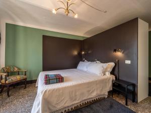 a bedroom with a large bed and a chair at Holiday Home La Rocchetta 1915-2 by Interhome in Cortandone