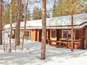 a log cabin in the woods in the snow at Holiday Home Sirkan ojus 1 by Interhome in Sirkka