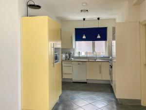 een keuken met witte apparatuur en een gele muur bij Holiday Home Afterdaan by Interhome in Elim