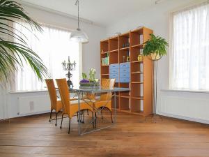 une salle à manger avec une table en verre et des chaises jaunes dans l'établissement Holiday Home Afterdaan by Interhome, à Elim
