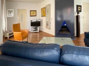 un salon avec un canapé bleu et une table en verre dans l'établissement Holiday Home Afterdaan by Interhome, à Elim