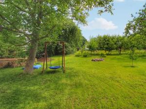 a playground in a yard with a tree at Holiday Home Libel by Interhome in Libel +28 photos