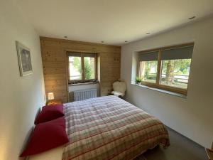 a bedroom with a bed and two windows at Apartment Ilse EG by Interhome in Fieschertal