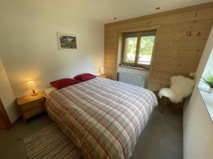 Un dormitorio con una cama con almohadas rojas y una ventana en Apartment Ilse EG by Interhome, en Fieschertal