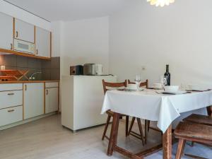eine Küche mit einem Tisch mit einer weißen Tischdecke in der Unterkunft Apartment Mont Fort 35 by Interhome in Siviez