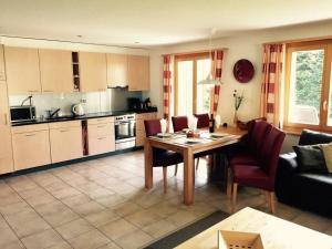 een keuken en een woonkamer met een tafel en stoelen bij Apartment Alpine Retreat by Interhome in Adelboden