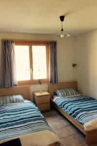 een slaapkamer met 2 bedden en een raam bij Apartment Alpine Retreat by Interhome in Adelboden