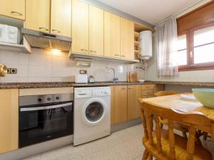 a kitchen with a washing machine and a table at Holiday Home Residencial Port Lligat by Interhome in Torredembarra