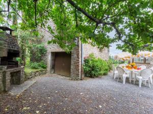 patio ze stołem i krzesłami oraz budynek w obiekcie Holiday Home Le Bois Bourdin by Interhome w mieście Pontorson