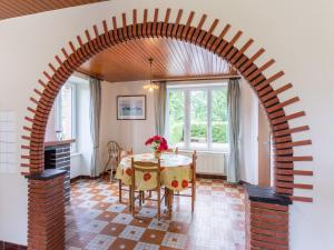 an archway in a room with a table and a fireplace at Holiday Home Le bois bourdin by Interhome in Pontorson