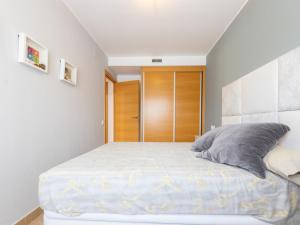 1 dormitorio con 1 cama grande y puerta de madera en Apartment Luxor by Interhome, en Torredembarra 17 fotos más