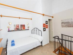 a white bedroom with a bed and a staircase at Holiday Home Sol by Interhome in Segur de Calafell
