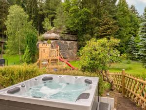 a hot tub in a garden with a playground at Holiday Home Dunja by Interhome in Hain