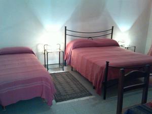 een slaapkamer met 2 bedden met roze lakens en verlichting bij B&B Su Rizolu in Sagama