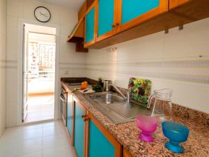 een keuken met een wastafel en een klok aan de muur bij Apartment Esmeralda-4 by Interhome in Calpe