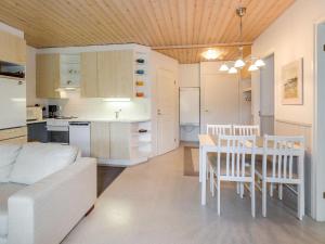 uma cozinha e uma sala de estar com mesa e cadeiras em Holiday Home Loma-koli 6 by Interhome em Hattusaari