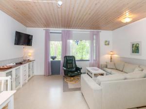 uma sala de estar com um sofá e uma cadeira em Holiday Home Loma-koli 6 by Interhome em Hattusaari