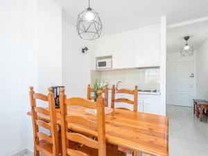 cocina y comedor con mesa de madera y sillas en Apartment Gran Reserva-35 by Interhome, en Empuriabrava