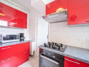 - une cuisine avec des placards rouges et une cuisinière dans l'établissement Holiday Home Les Dunes-3 by Interhome, à Quiberon