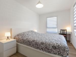 Un dormitorio blanco con una cama y un escritorio. en Holiday Home Vinci by Interhome, en Royan