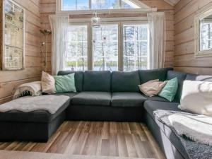 a living room with a blue couch and windows at Holiday Home Tuliniemi by Interhome in Iisalmi