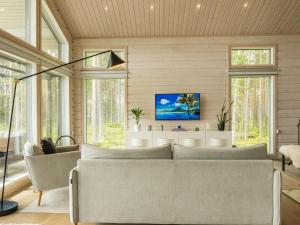 a living room with a couch and a tv at Holiday Home Merilänranta by Interhome in Manamansalo