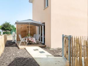 a patio with a table and an umbrella at Apartment SC H01 by Interhome in Mimizan