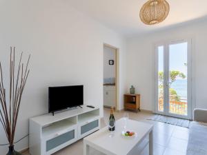 sala de estar blanca con TV y mesa en Villa La Madrague by Interhome, en Hyères