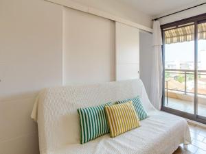 a white couch with two pillows in a room with a window at Apartment Saint James-13 by Interhome in Le Lavandou