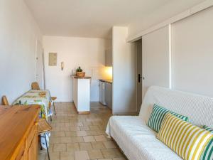 a living room with a couch and a kitchen at Apartment Saint James-13 by Interhome in Le Lavandou +19 photos