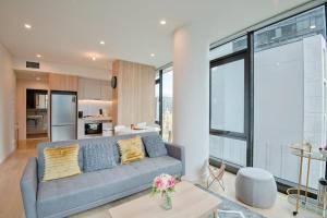 a living room with a couch and a kitchen at MetaWise Sydney CBD Luxury City view 2BED Apartment in Sydney